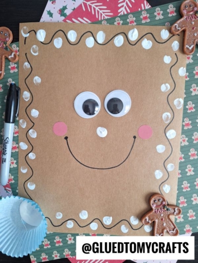 Draw squiggles around a sheet of light brown cardstock paper and use your index finger to add the "frosting" for the gingerbread man face
