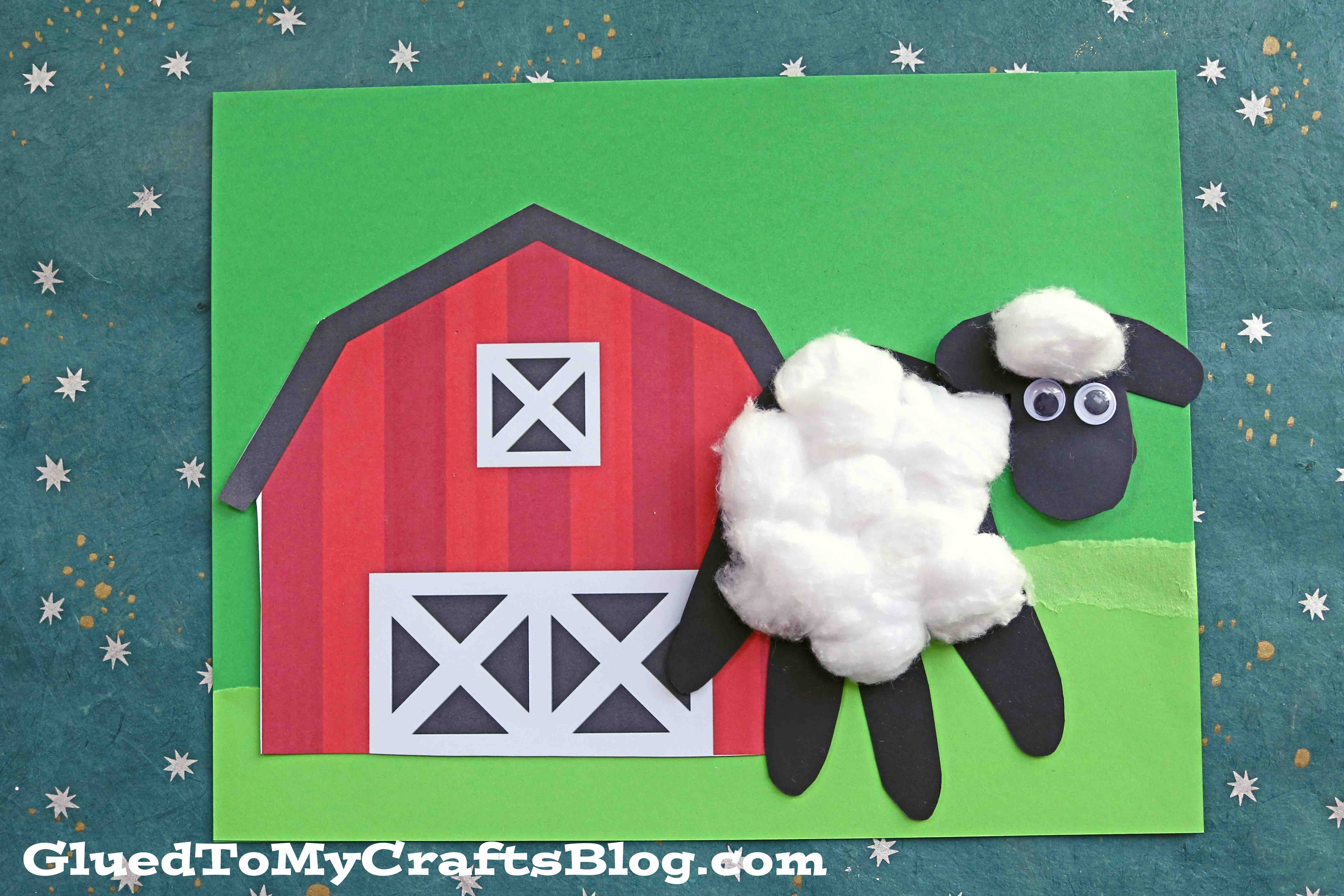 A children's craft of a red barn and a handprint baby sheep made from a black handprint, googly eyes, and cotton balls on green paper, with GluedToMyCraftsBlog.com at the bottom.