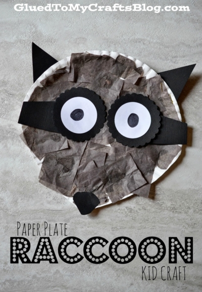 A paper plate raccoon craft decorated with black and gray tissue paper, plus black paper ears, eyes, and nose. The text reads Paper Plate Raccoon Kid Craft with GluedToMyCraftsBlog.com at the top.