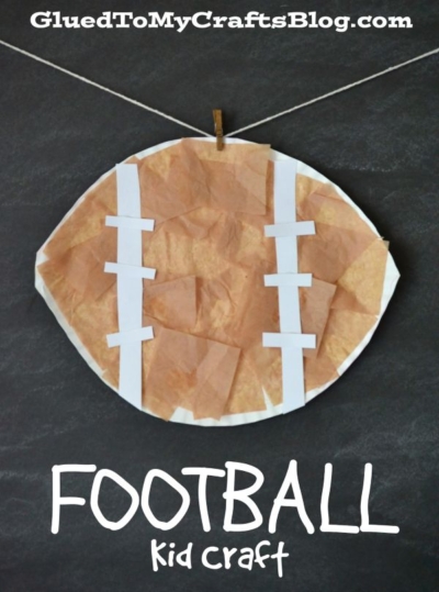 A paper plate football decorated with brown tissue paper and white paper strips, hanging from a string. Text reads FOOTBALL Kid Craft and GluedToMyCraftsBlog.com.