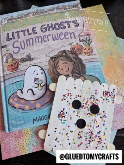 Children’s book “Little Ghost’s Summerween” with pastel papers and a Popsicle Stick Ghost craft, decorated with googly eyes and colorful glitter. @gluedtomycrafts watermark is visible.