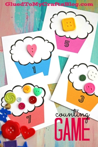 Four Cupcake Counting Game cards feature numbers 1, 3, 5, and 7, each cupcake topped with colorful buttons to match. This fun counting game for children includes assorted buttons and shapes scattered around for extra play.