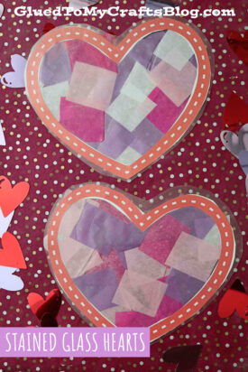 Two paper hearts filled with pink, purple, and white tissue squares create a stained glass hearts effect on a purple polka dot background, surrounded by cut-out hearts. Text reads “Stained Glass Hearts” and “GluedToMyCraftsBlog.com.”.