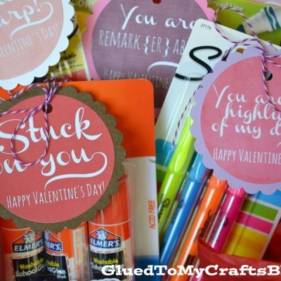 A basket filled with school supplies, each with a pink or red Valentines Day tag and message.
