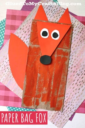 A Paper Bag Fox with orange paper ears, tail, and nose, plus white and black paper eyes, sits atop layered, colorful patterned backgrounds. Text reads Paper Bag Fox.