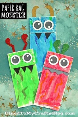 Three colorful paper bag monsters—green, blue, and red—each with big googly eyes, black paper fangs, and glittery antennae, stand on a star-patterned background. Text reads Paper Bag Monster.