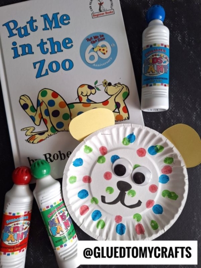 Children’s craft activity inspired by Put Me in the Zoo: the book is shown next to a paper plate bear face decorated with colorful dots, paint dabbers, and yellow paper ears—perfect for fans of Dr Seuss Kid Crafts. Username @GLUEDTOMYCRAFTS appears at the bottom.