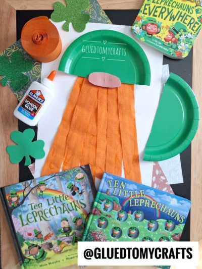 A St. Patrick’s Day craft featuring torn pieces of orange crepe paper and a green paper plate hat to make a leprechaun gnome on white paper. There is a watermark @GLUEDTOMYCRAFTS