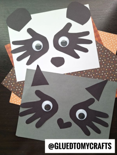 Two animal face crafts made from paper, perfect as handprint gift ideas, each with big googly eyes, black paper cutouts for facial features, and different colored backgrounds—the top one resembles a panda and the bottom one a cat.