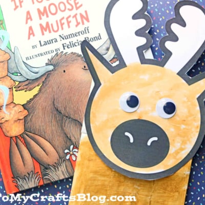 A children’s book titled If You Give a Moose a Muffin lies on polka dot paper, next to a paper bag moose puppet made with a brown paper bag, paper antlers, googly eyes, and a black snout.