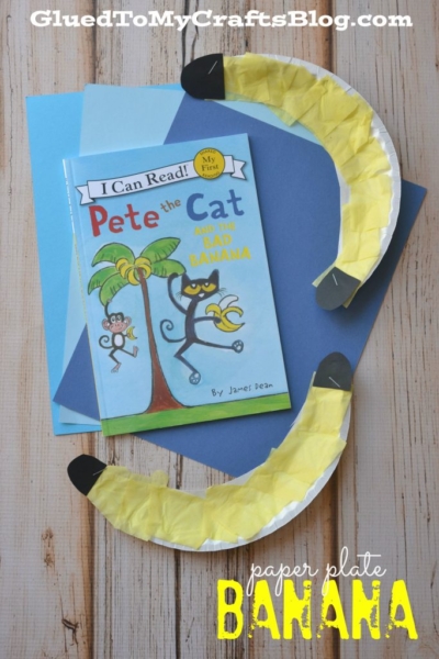 A children’s book titled Pete the Cat and the Bad Banana sits on blue paper, surrounded by two banana crafts made from paper plate bananas with yellow tissue and black tips.