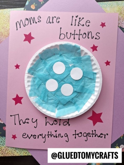 A pink card with red stars showcases a paper plate button decorated to look like a blue button, with the words Moms are like buttons. They hold everything together written around it. @GLUEDTOMYCRAFTS is at the bottom.