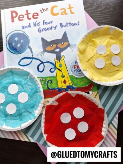 A Pete the Cat book with three cute button paper plates, each resembling buttons and decorated with colored tissue paper and white paper circles. The plates are yellow, blue, and red. Text @GLUEDTOMYCRAFTS appears at the bottom.