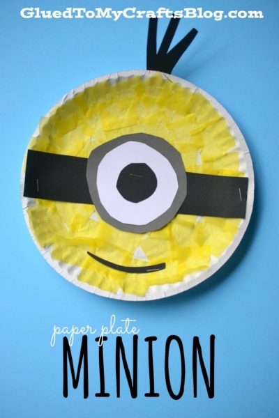 A paper plate decorated to look like a Minion, with yellow tissue paper, black paper for the band and hair, a large white and gray eye in the center, plus craft stick minion inspiration. Text reads paper plate MINION and GluedToMyCraftsBlog.com.