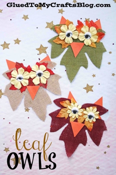 Three charming leaf owls, crafted from fabric leaves, orange paper beaks, and cream flowers for eyes, are arranged on a white surface sprinkled with gold stars and confetti. Text reads leaf OWLS.