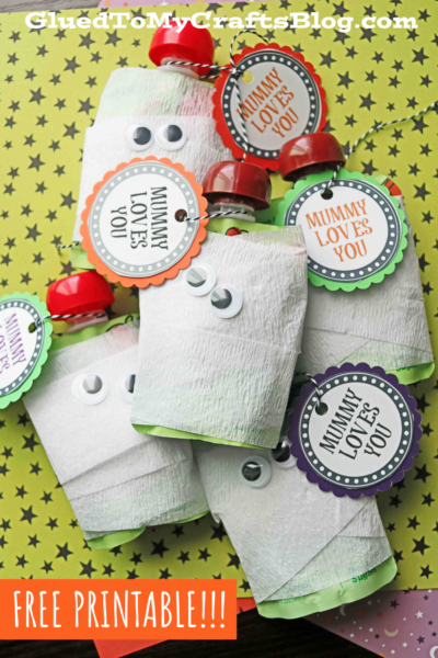 Several apple sauce pouches are wrapped in white crepe paper to look like mummy squeeze snacks, complete with googly eyes and tags reading “Mummy Loves You.” The image includes a “FREE PRINTABLE!!!” banner at the bottom.