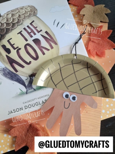 A children’s book titled Be the Acorn, an acorn craft using a paper plate, brown paper hand cutout, fake fall leaves, and star-patterned orange paper—perfect for Fall Craft Ideas. @gluedtomycrafts appears in three spots.