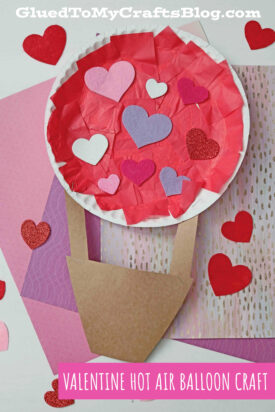 A Valentine-themed paper plate hot air balloon craft made with red and pink tissue paper, heart shapes, and brown paper for the basket, displayed on patterned backgrounds with scattered heart cutouts.