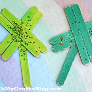 A green and blue Popsicle Stick Clover adds a playful touch to your crafts.