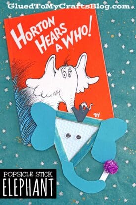 A Horton Hears a Who! book sits on a teal, star-patterned background. Beside it is a Popsicle Stick Horton craft—a popsicle stick elephant with blue ears, curled trunk, and purple pom-pom—labeled Popsicle Stick Elephant.
