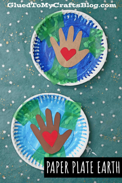 Two paper plates painted blue and green to create a paper earth craft, decorated with handprint cutouts and red paper hearts in the center, displayed on a starry background. Text reads “Paper Plate Earth.”.