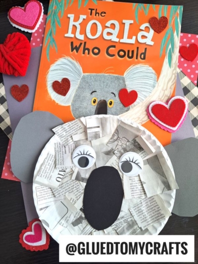 A children’s book titled The Koala Who Could is surrounded by heart decorations. In front, a paper plate newspaper koala with googly eyes stands out. @GLUEDTOMYCRAFTS is written at the bottom.