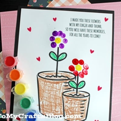 A craft project shows two flower pots with fingerprint flowers made from colorful petals on a card, surrounded by small red hearts. Paint pots and a brush are beside it. The card reads, I made you these flowers with my finger and thumb...