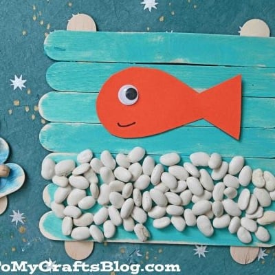 A couple of popsicle sticks with fish and beans, perfect for creating your own popsicle stick fish bowl craft.