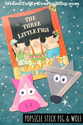 A children’s book, The Three Little Pigs, is displayed on a starry background alongside a popsicle stick pig and popsicle stick wolf made from colored sticks, paper, and googly eyes. Text reads THREE LITTLE PIGS CRAFT: POPSICLE STICK PIG & WOLF.