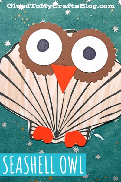 A paper seashell owl craft made to look like an owl, with large round eyes, an orange beak, and orange feet, on a teal background with white stars. Text at the top reads GluedToMyCraftsBlog.com.