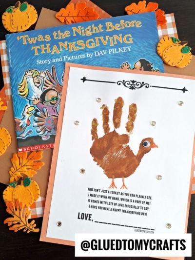 Children’s Thanksgiving craft with a handprint turkey on white paper, the sweet handprint turkey poem “This isn’t just a turkey as you can plainly see…” beside “‘Twas the Night Before Thanksgiving” and festive pumpkin decorations.