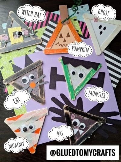 Seven Halloween-themed triangle crafts, made to look like popsicle stick Halloween friends—including a witch hat, ghost, pumpkin, cat, monster, mummy, and bat—each decorated with googly eyes and arranged on colorful paper. @GLUEDTOMYCRAFTS is written at the bottom.