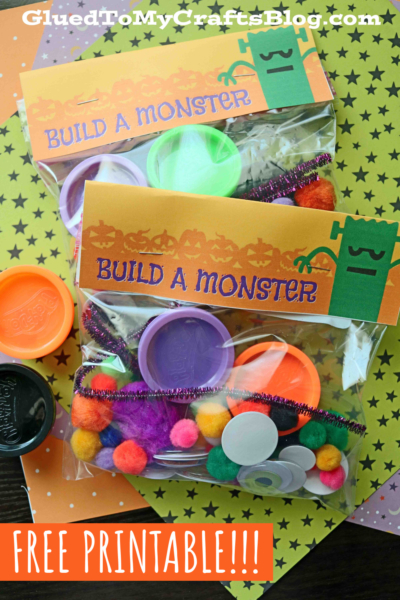 A “Build a Monster” craft kit with colorful pom-poms, pipe cleaners, googly eyes, and plastic lids in clear bags. An orange label with a green monster sits on star-patterned paper. Text reads “FREE build a monster printable!!!”.