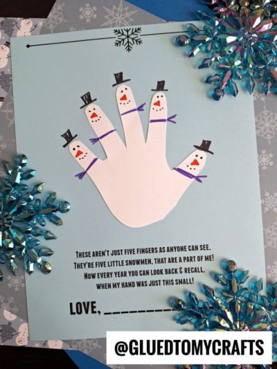 A blue card displays a snowman handprint, each finger turned into a snowman. Snowflakes and craft gems add sparkle. The text includes a sweet handprint snowman poem and space at the bottom for a child’s name.