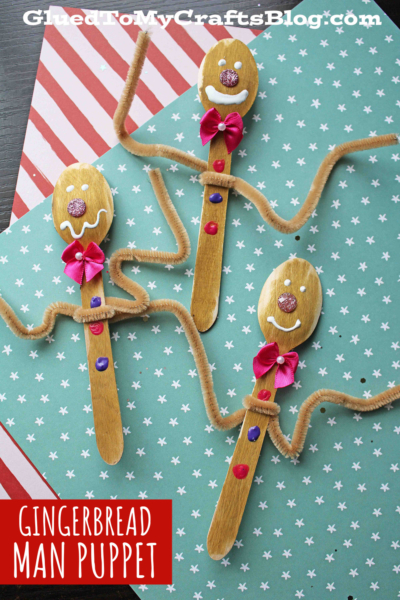 Three craft spoon gingerbread man puppets made from wooden spoons, decorated with brown pipe cleaners for arms, painted faces and buttons, and red bows. Set on a star-patterned background. Text: GINGERBREAD MAN PUPPET.