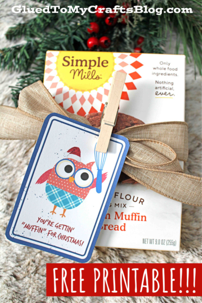 A muffin mix box with a gold ribbon and a gift tag featuring a cartoon owl and the phrase "you get muffin for Christmas!" Text above reads FREE PRINTABLE!!! with the blog name at the top.