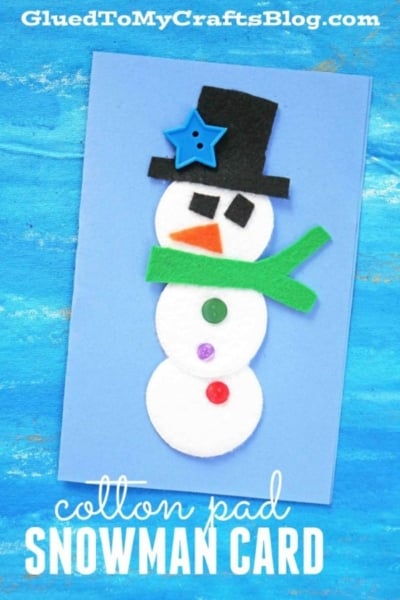 A handmade snowman card on blue paper, using three cotton pads for the body, felt shapes for the hat, scarf, and nose, a button, and colored buttons for decorationāperfect inspiration if you love crafting cotton pad snowmen or making a snowman puppet. Text: cotton pad SNOWMAN CARD.