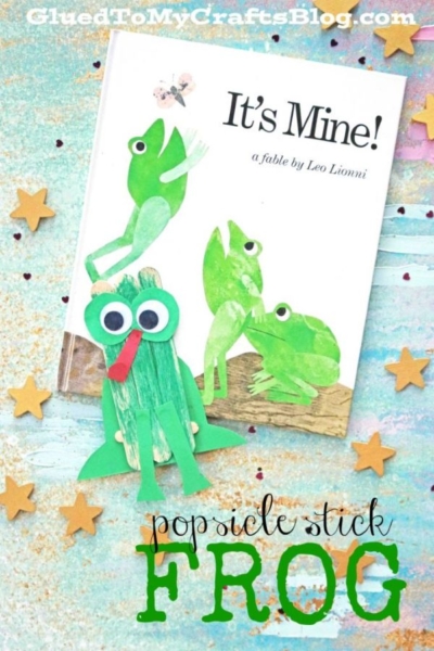 Children’s book “It’s Mine!” with charming green frog illustrations, accompanied by a playful popsicle stick frog craft featuring googly eyes and a red tongue, all surrounded by gold star-shaped confetti on a light background.