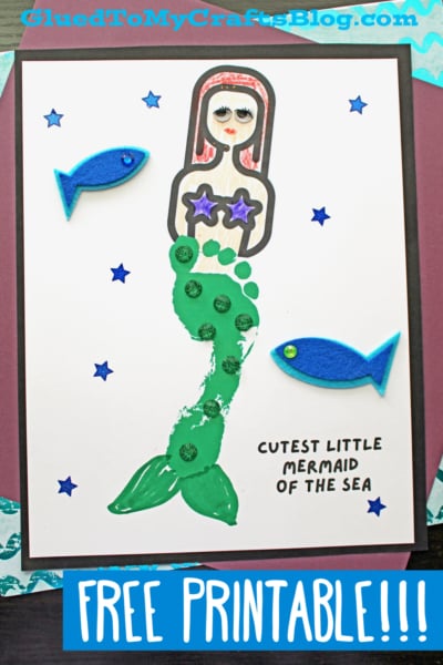 A children’s craft artwork of a footprint mermaid made with paint, felt, and star stickers. The mermaid has green fins, purple starfish top, and red hair, surrounded by blue fish and stars. Texts read “CUTEST LITTLE MERMAID OF THE SEA” and “FREE PRINTABLE!!!”.
