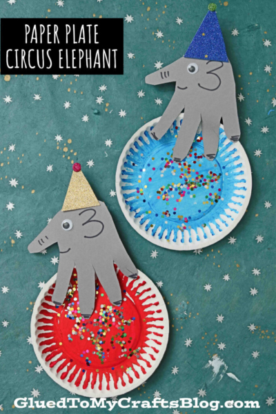 Two festive circus elephant crafts, perfect as an elephant craft for kids, made from gray paper handprints and colorful paper plates, decorated with paint, glitter, and party hats, displayed on a star-patterned background.