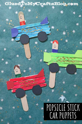 Three colorful popsicle stick car puppets with drawn faces, paper tires, and gold glitter details are arranged on a teal star-patterned background. The text reads Popsicle Stick Car Puppets—perfect for creative play and DIY fun!.