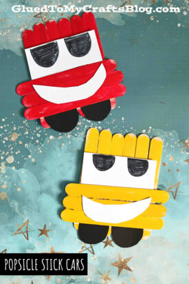 Two Popsicle Stick Cars, one red and one yellow, with big smiling mouths, large black-and-white eyes, and black wheels, sit on a blue background with gold stars. Text reads “POPSICLE STICK CARS.”.