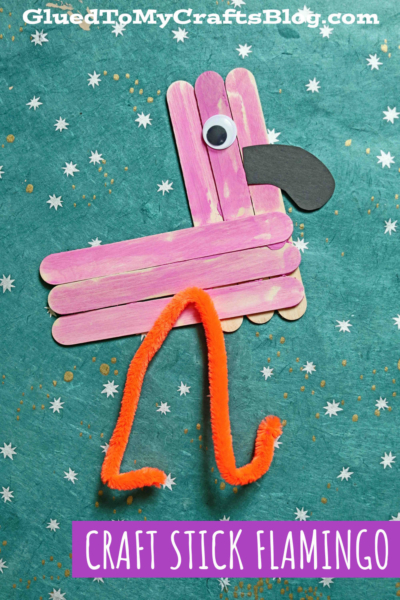 A craft stick flamingo features pink craft sticks, a googly eye, black paper beak, and orange pipe cleaner legs, set against a blue-green background with white star shapes. Text reads “CRAFT STICK FLAMINGO.”.