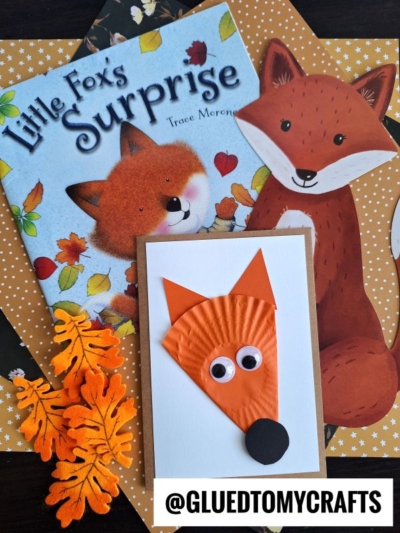 Childrens book Little Fox’s Surprise, fox illustrations, and cupcake liner fox cards with googly eyes and paper leaves are arranged on an orange polka dot background. @gluedtomycrafts watermark is present.
