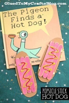 A children’s book titled The Pigeon Finds a Hot Dog! is shown with two popsicle stick hot dog crafts, each painted with pink centers and squiggles of yellow and red like mustard and ketchup.