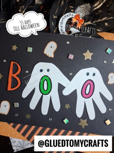 A Halloween craft features two white handprints as ghost Os in the word BOO on black paper, accented with ghost stickers, stars, and a “55 days till Halloween” text—making it perfect for halloween keepsakes. @GLUEDTOMYCRAFTS is displayed at the bottom.