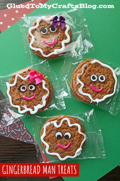 Four packaged Gingerbread Man Treats, decorated with white icing, candy eyes, and colorful bows and smiles, are arranged on a festive green and red background. The text reads Gingerbread Man Treats—perfect for fans of oatmeal cream pie gingerbread man flavors.