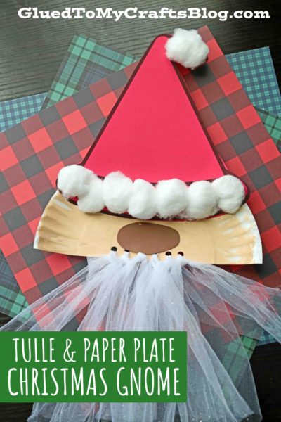 A festive paper plate santa gnome craft featuring a red paper hat, cotton balls, and white tulle, displayed on plaid paper with the text Tulle & Paper Plate Christmas Gnome. Perfect for a fun paper plate tulle santa activity!.