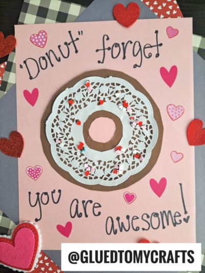 A handmade valentine donut card featuring a paper doily donut, red and pink hearts, and the message “Donut forget you are awesome!” displayed on a charming pink background.