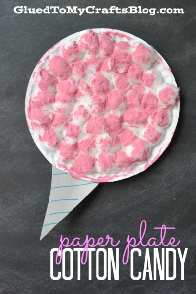 A craft project that looks like cotton candy: a paper plate covered with white and pink fluffy material, resembling paper cotton candy, with a paper cone at the bottom. Text reads paper plate cotton candy.